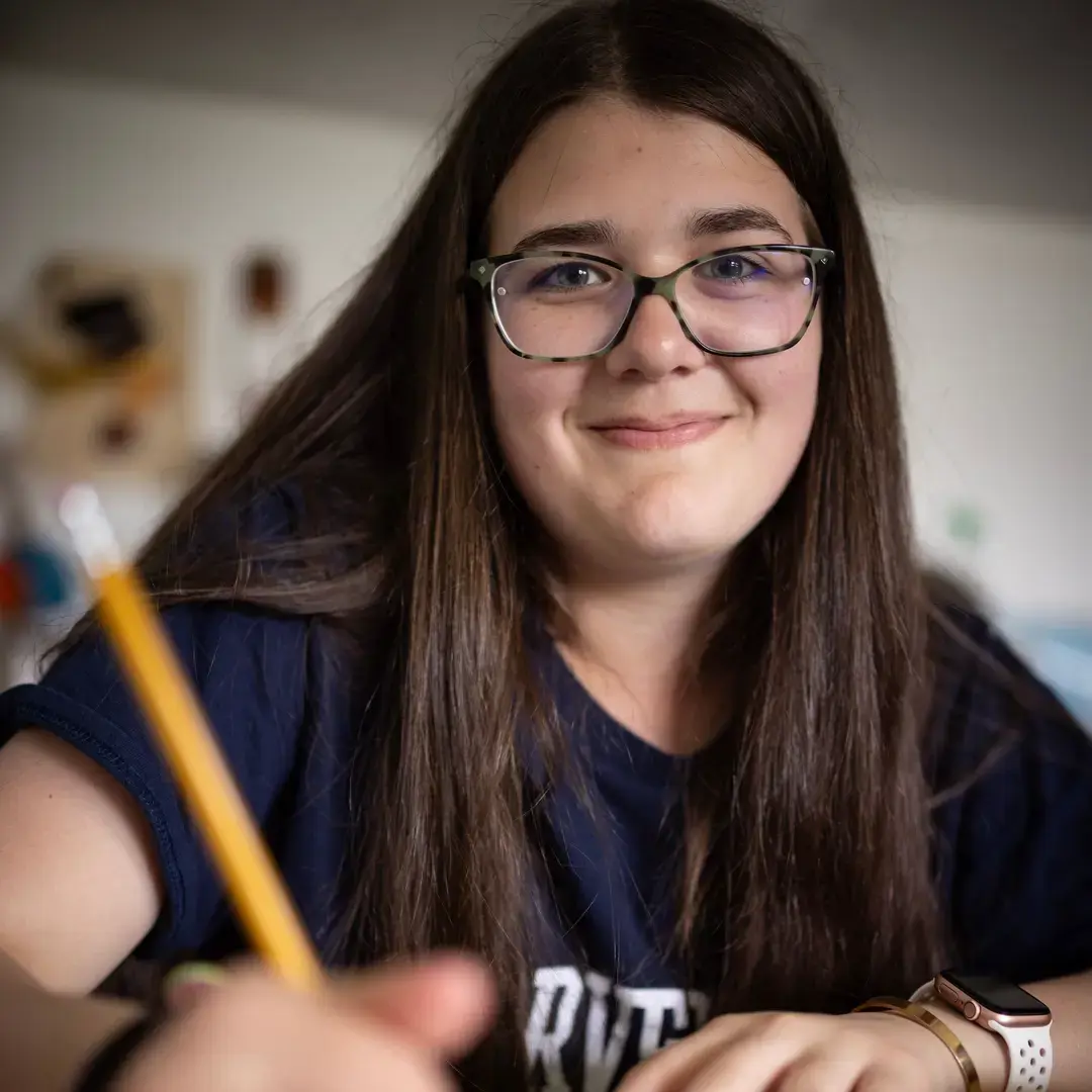 Student doing classwork and smiling