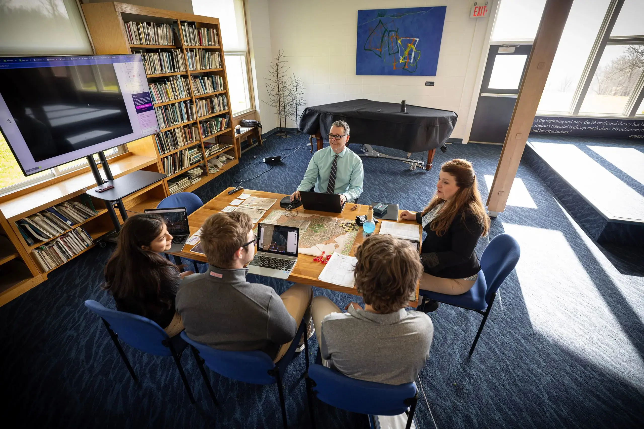 Students studying in library with teacher