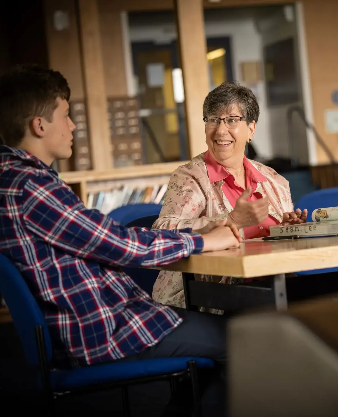 Teacher helping students in library