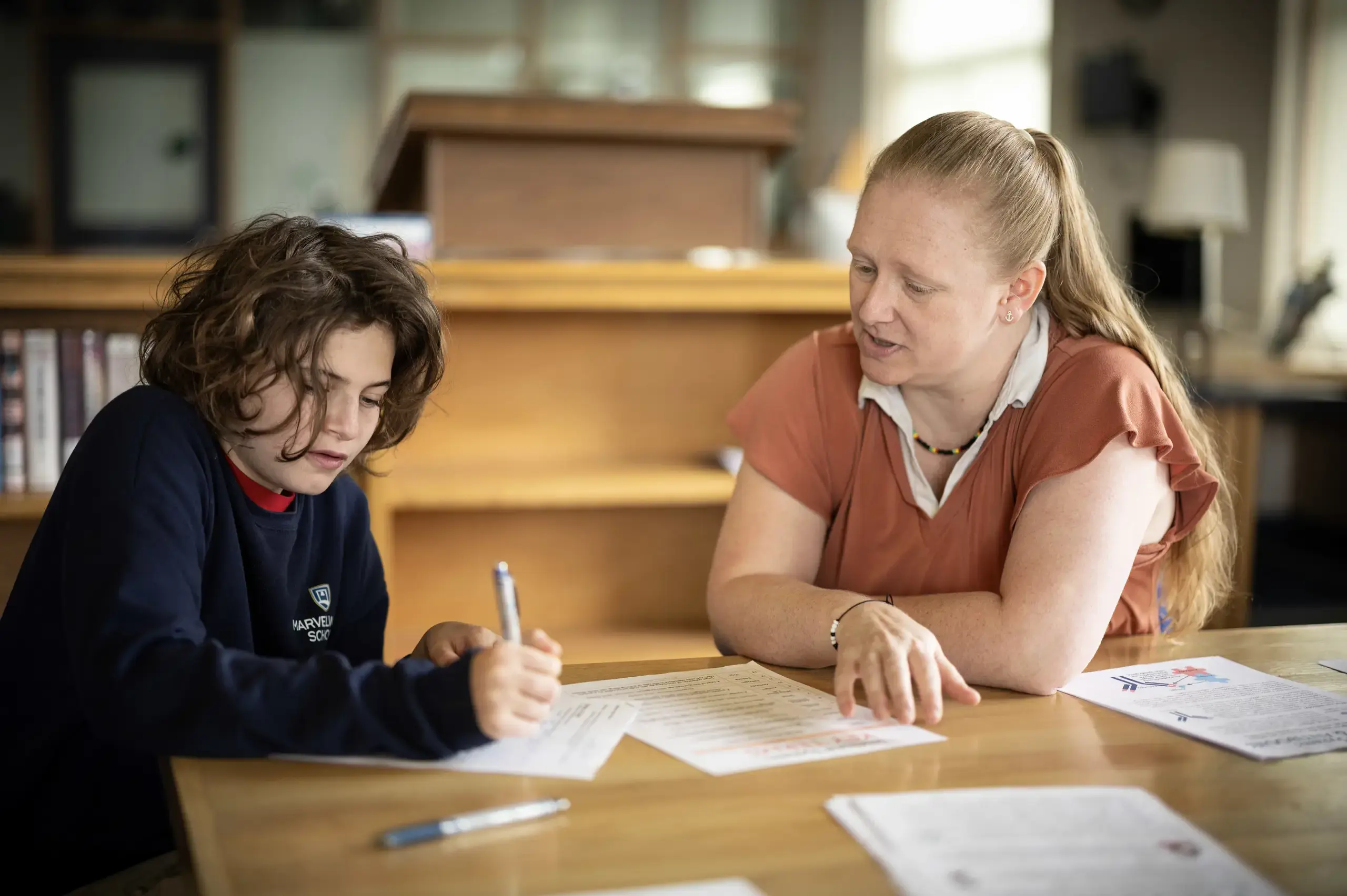 Student and teacher in library together