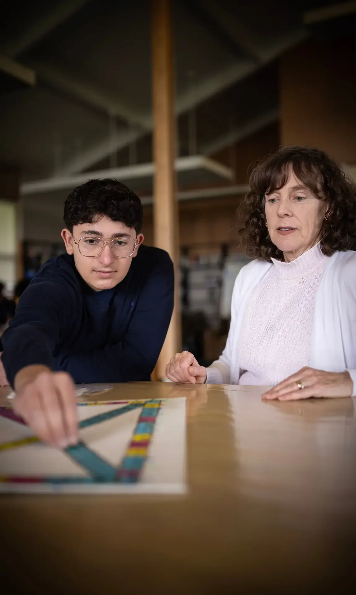 Teacher helping student in library