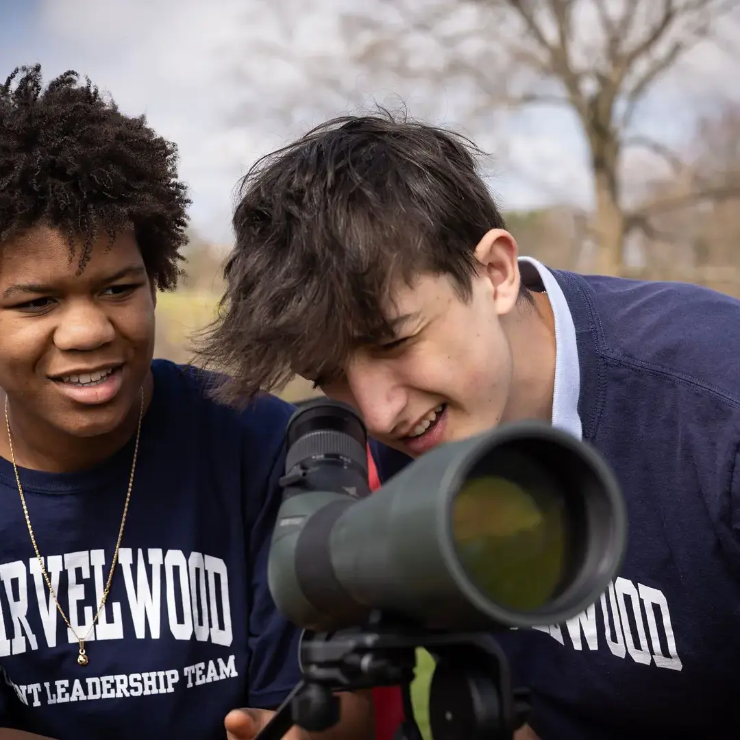 Students looking through binocular