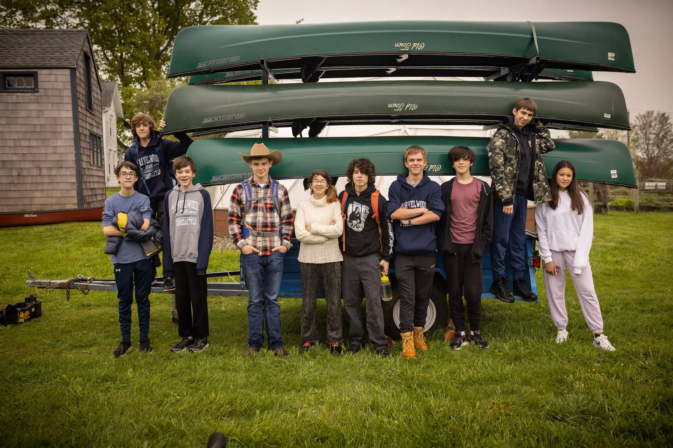 Students standing in front of canoe