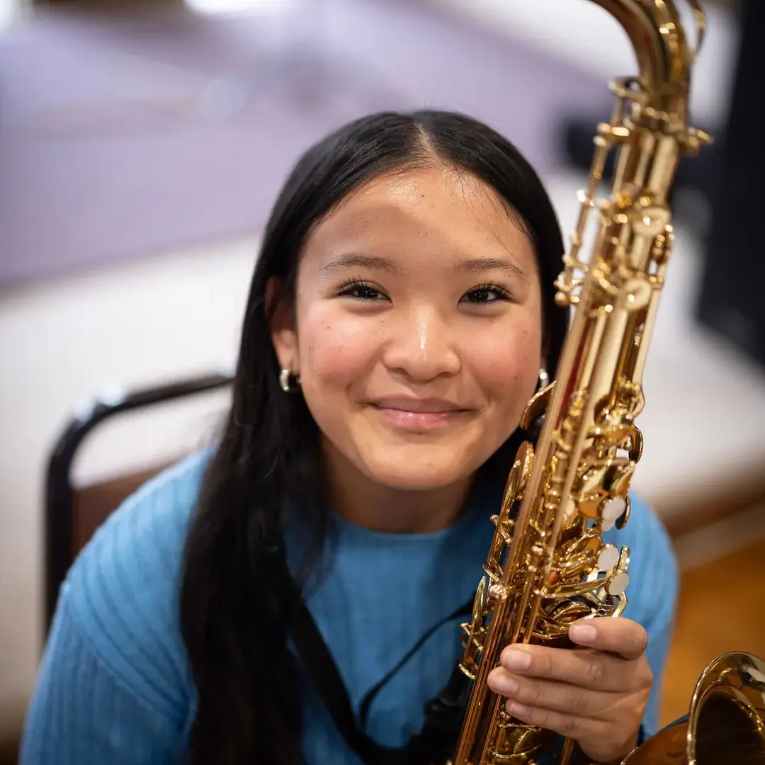 Student holding saxophone