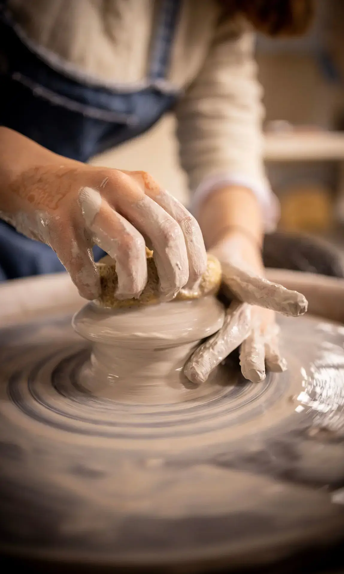 Student throwing pottery