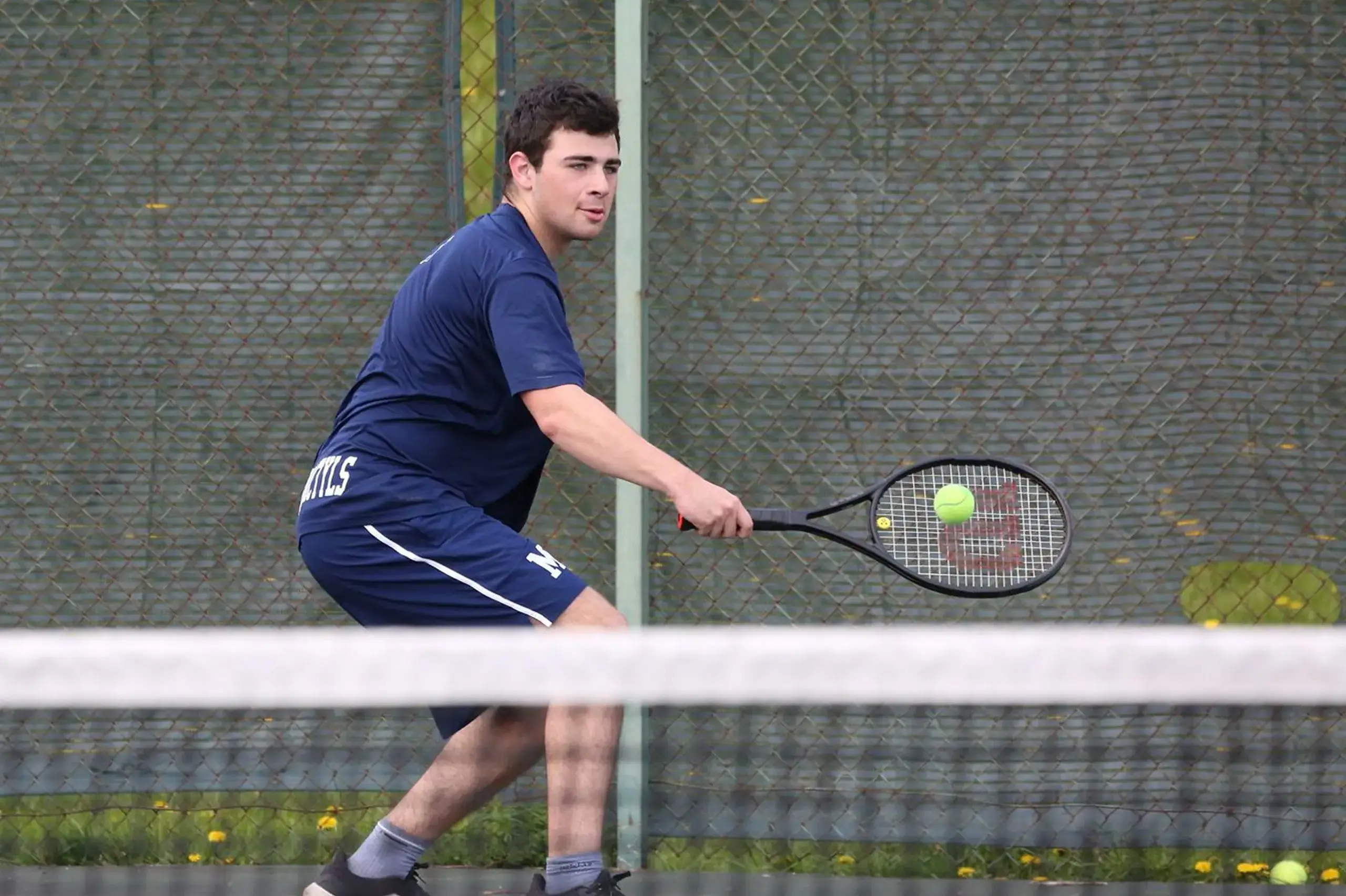 Student playing tennis