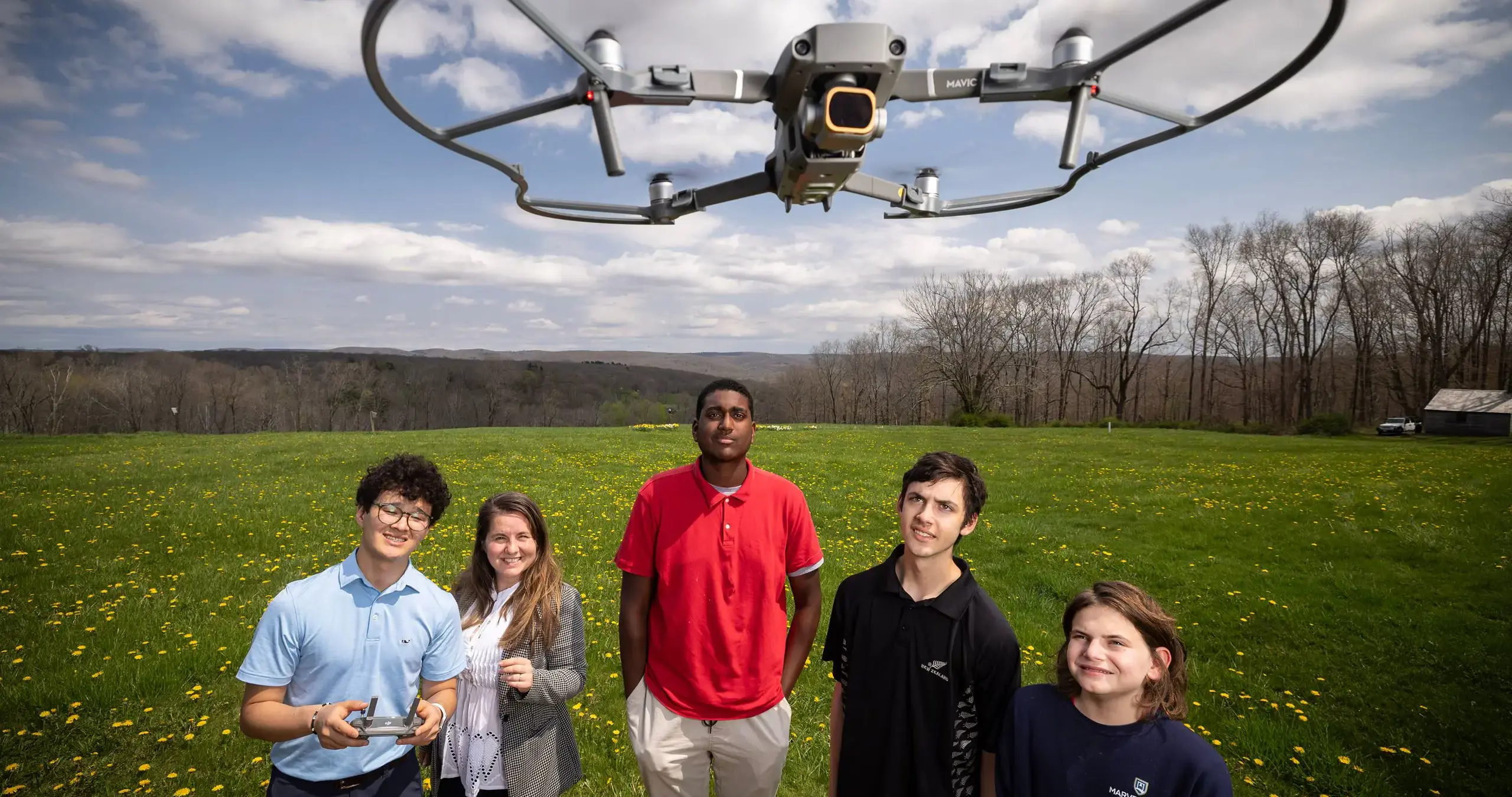 Students flying drone in field
