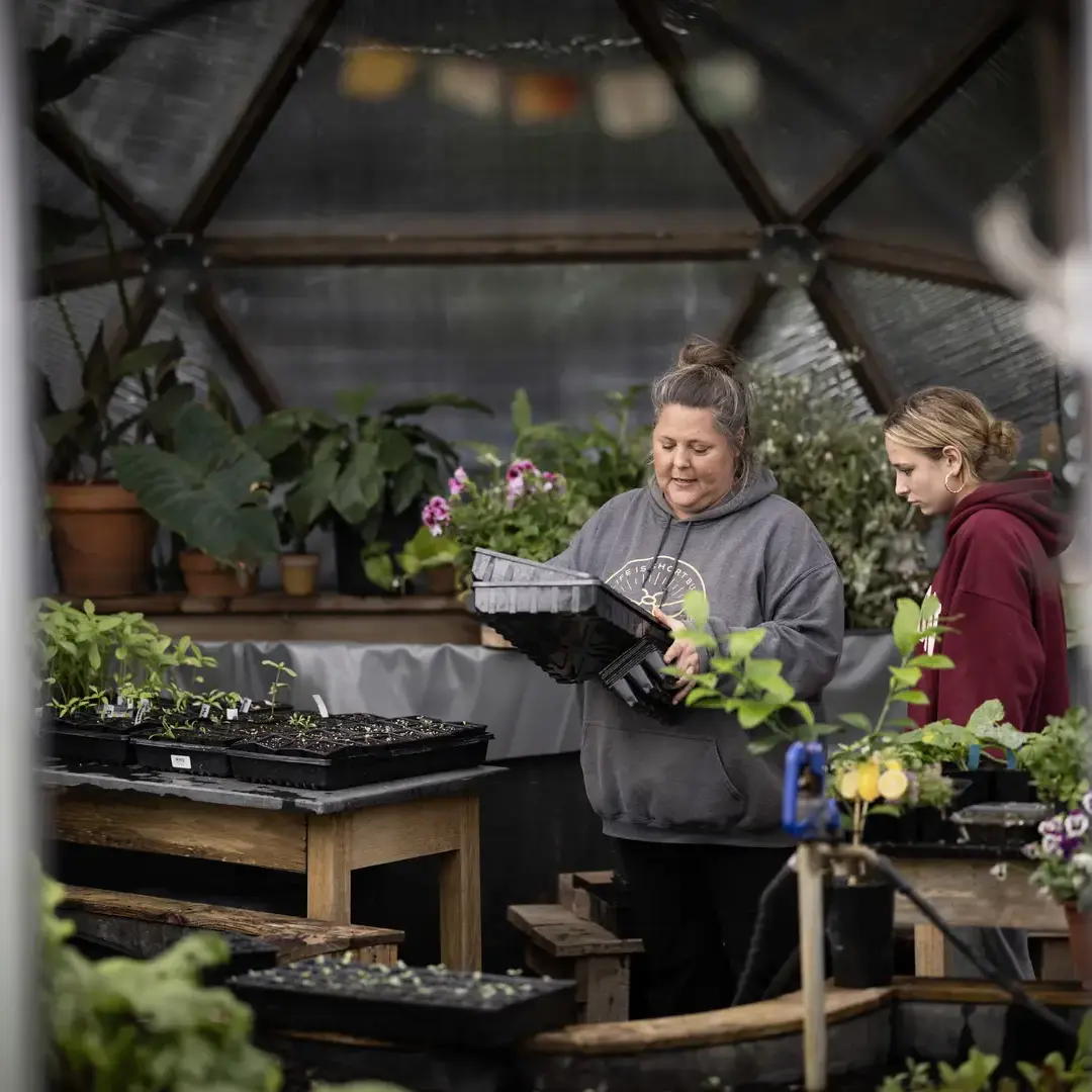 Teacher assisting student with gardening