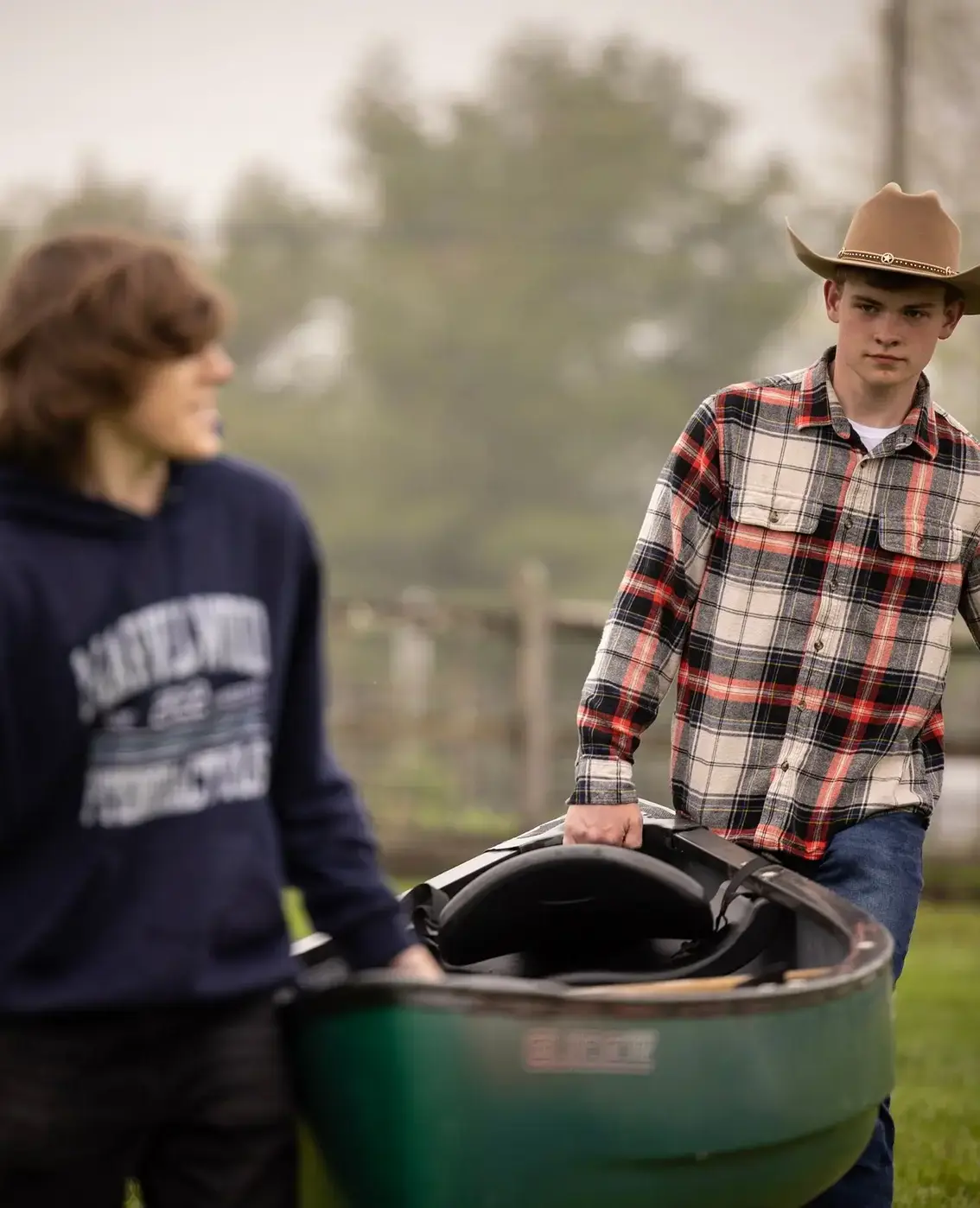 Students helping each other carry canoe