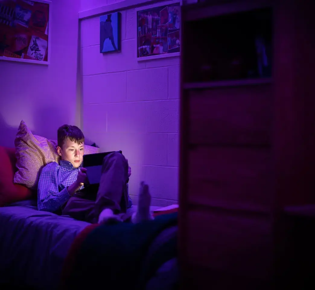 Student doing schoolwork on laptop in dorm