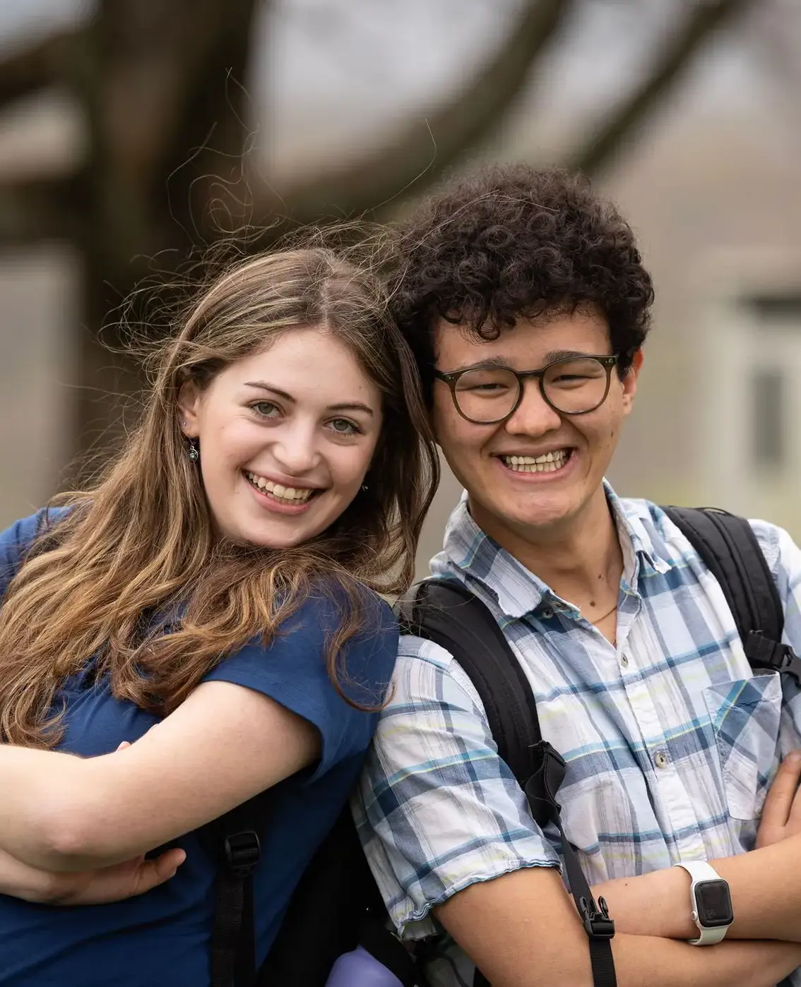 Students crossing arms with backs against each other while smiling
