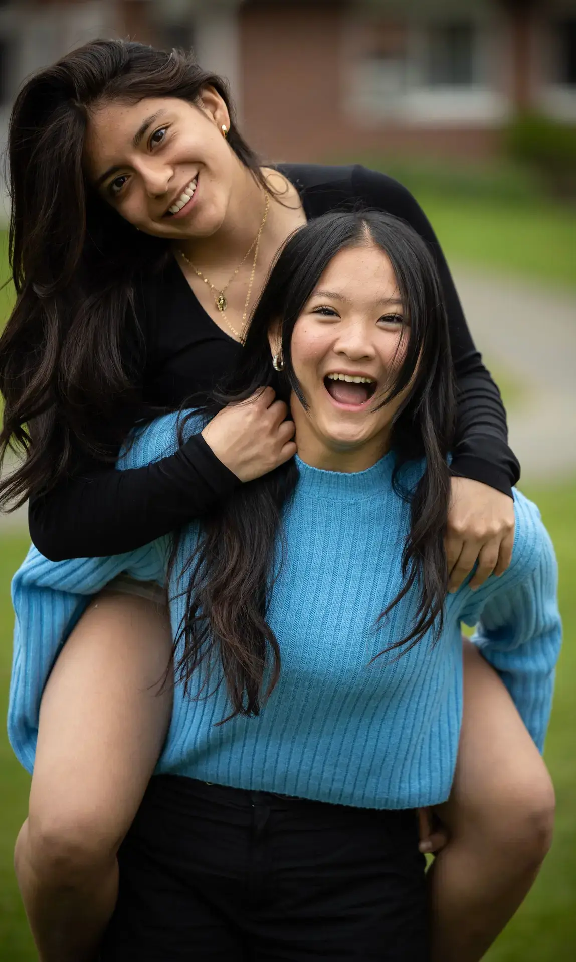 Students piggy backing and smiling on campus