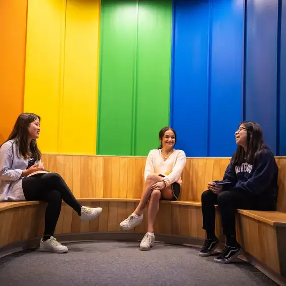 Students sat in front of rainbow mural