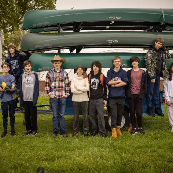 Students stood in front of canoes