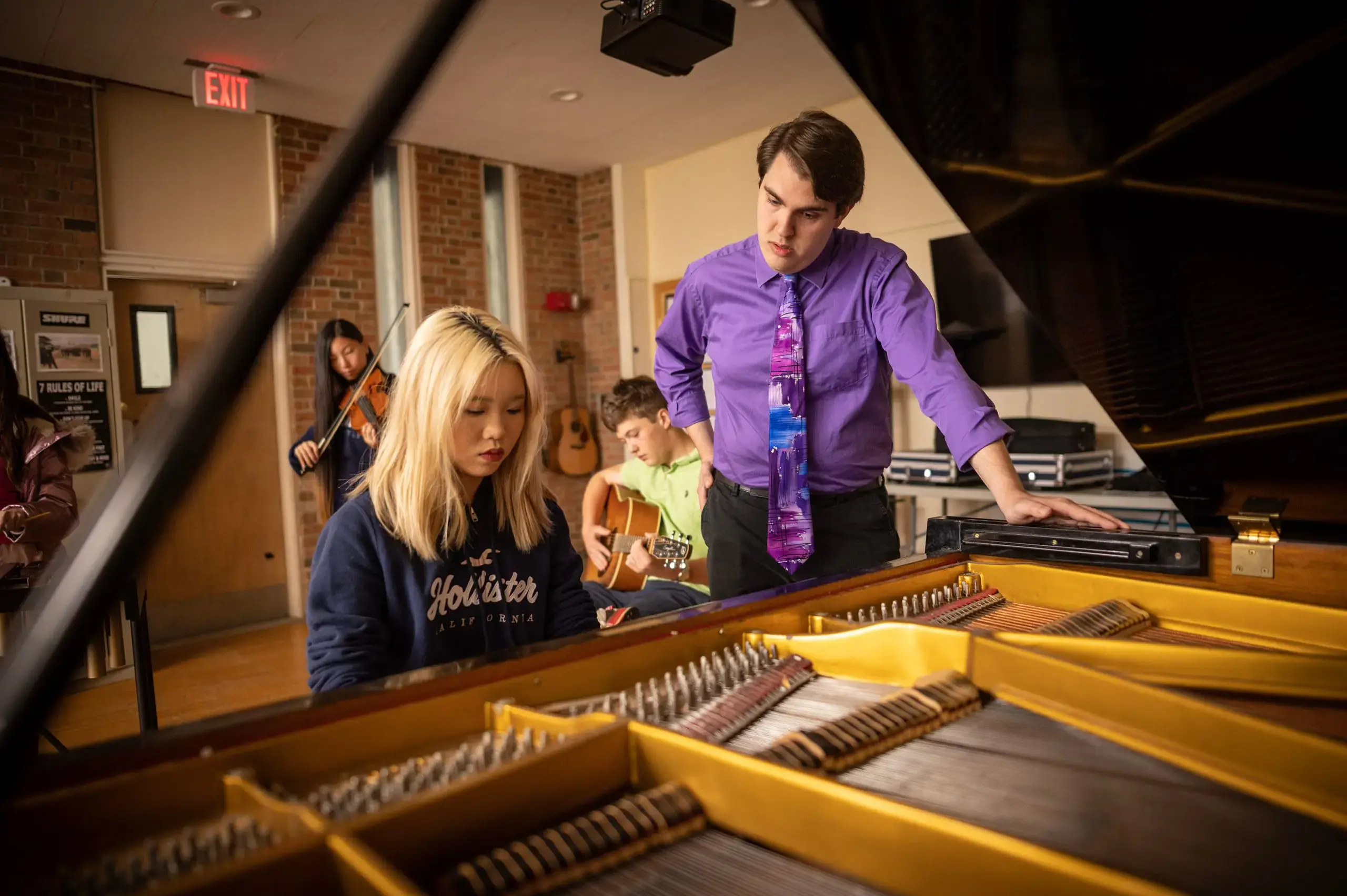 Teacher assisting student in music class