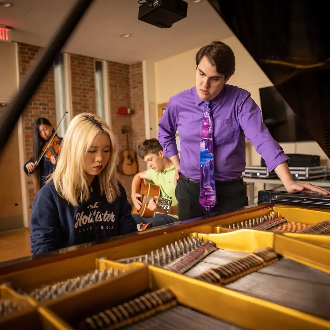 Student playing piano in class